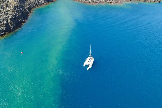 Full Day Santorini Catamaran Private Cruise with meal and transfer - The lighthouse and Indian Head Rock add a different view