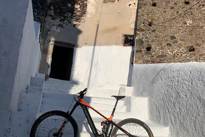 Private Electric Mountain Bike Experience and Tour in Santorini - Red lava rock above the beach