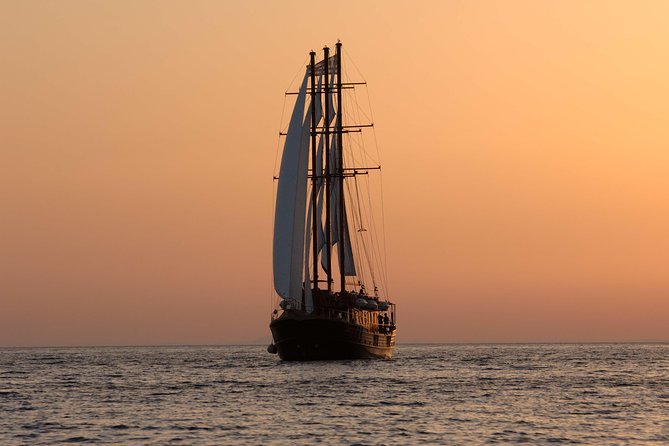 Santorini Caldera Sunset Sailing Cruise with Dinner and Wine - Sunset near Oia from the water