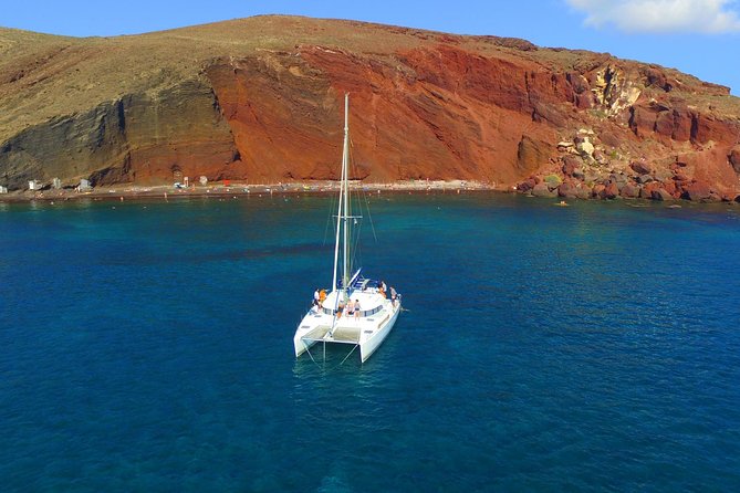 Santorini Full Day Catamaran Private Cruise incl. Meal, Drinks & Free Transport - The lighthouse, Aspronisi, and the volcanic coast