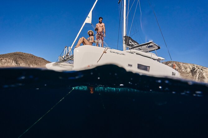 Santorini Oia: Luxury Sunset Cruise with Fresh Fish BBQ & Drinks - The lighthouse and Santorini’s southern coast