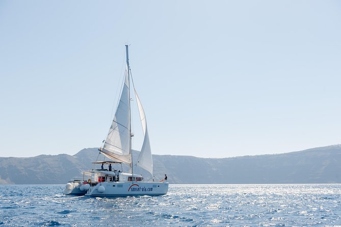 Santorini Small-Group Catamaran Sailing Trip(BBQ,drinks, transfer) - The lighthouse and volcano add the wider Santorini view